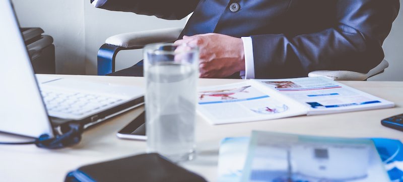 Busy office desk with glass of water