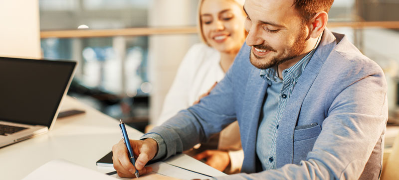 Happy couple filling out mortgage paper work